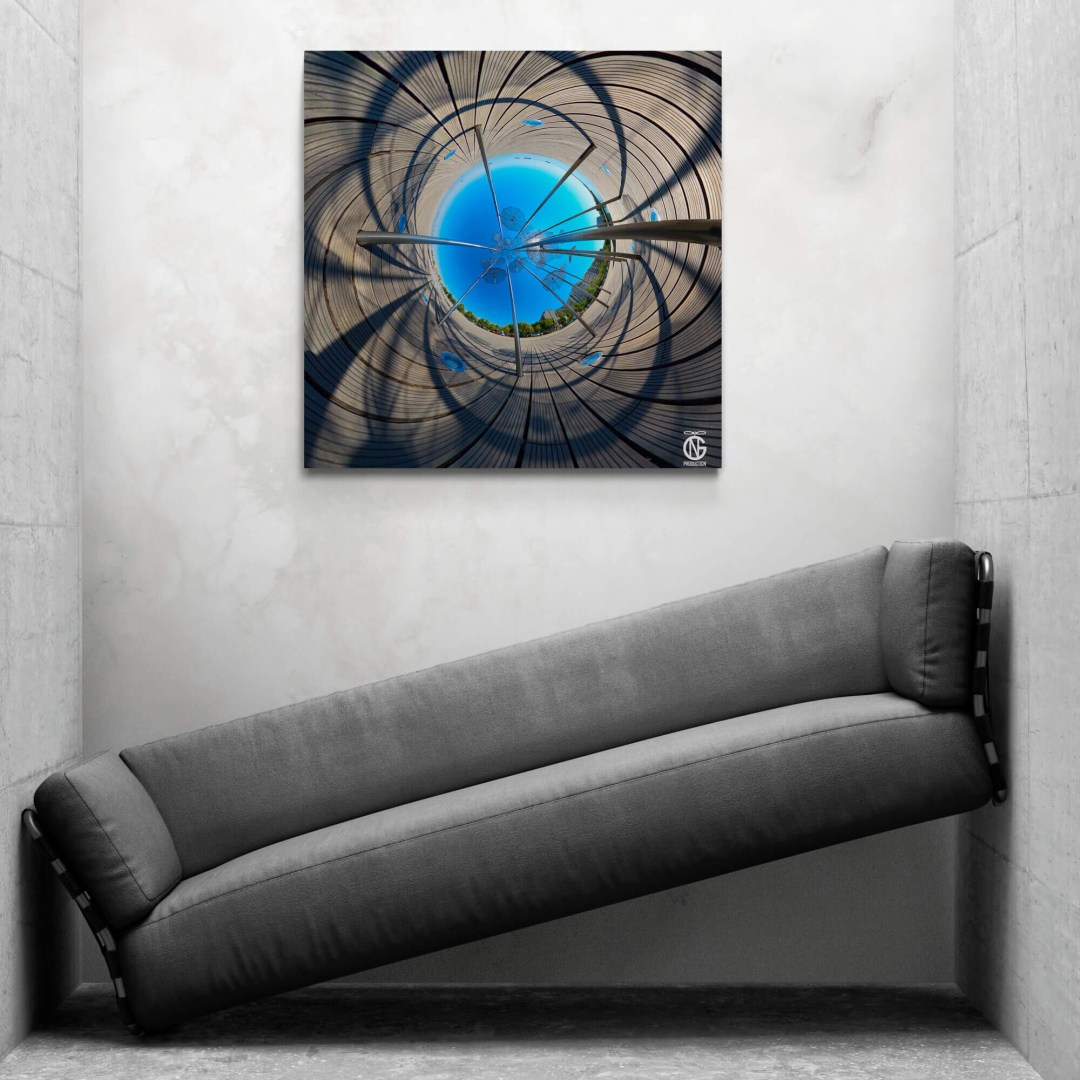 Inverted tiny-planet Umbrellas canvas on a concrete wall above a tilted sofa in a design alcove.